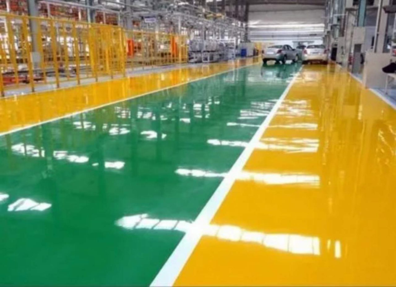 厂房车间环氧地坪施工实拍——环氧自流平,厂房车间内环氧自流平地坪,镜面反光明显,两侧有黄色区域与通道线,远处有车辆