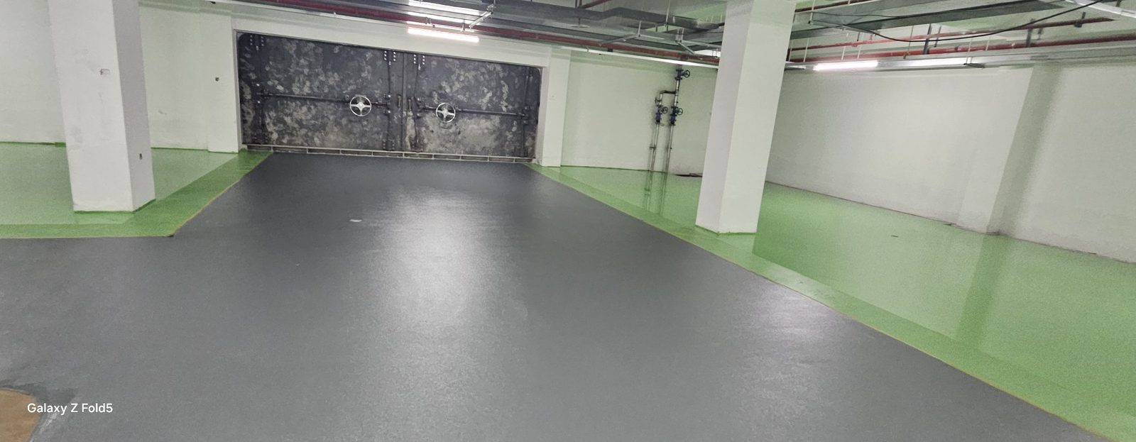 地下车库环氧地坪完工：行车道与停车位分色全景