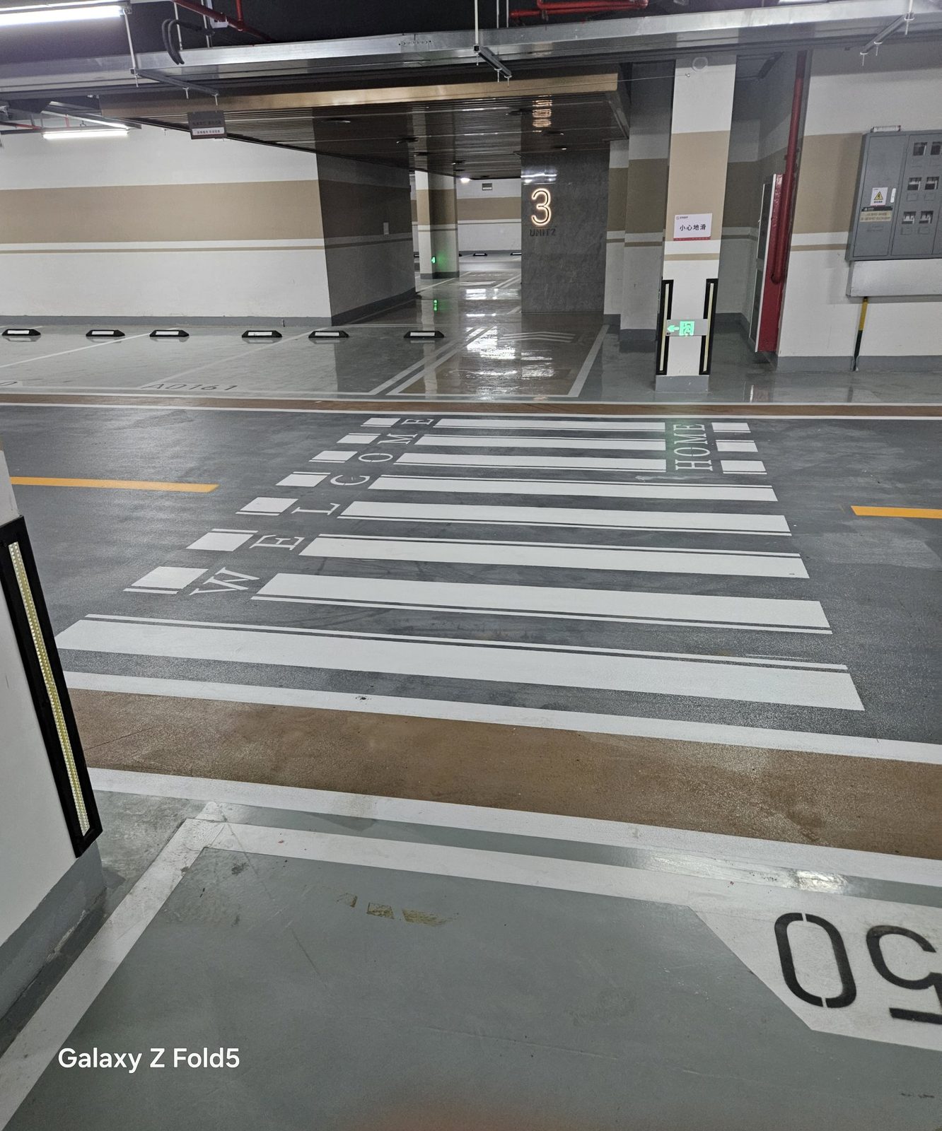 蓝城·云晟府地下车库：单元门厅前WELCOME HOME斑马线，光亮灰色环氧地面